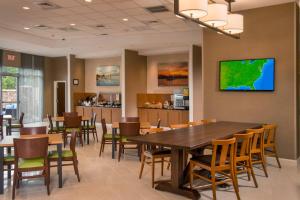 Fairfield Inn & Suites by Marriott Washington في واشنطن: غرفة طعام مع طاولة وكراسي خشبية كبيرة