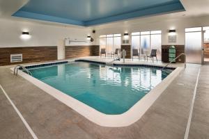 Fairfield Inn & Suites by Marriott Washington في واشنطن: مسبح داخلي كبير في غرفة الفندق ذات ماء أزرق