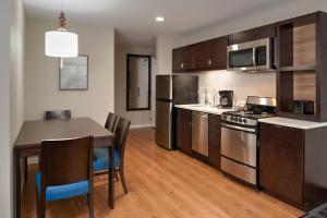 a kitchen with a table and a stove top oven at TownePlace Suites by Marriott Richmond in Richmond