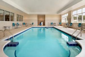 - une grande piscine d'eau bleue dans un bâtiment dans l'établissement TownePlace Suites by Marriott Joliet Minooka, à Minooka