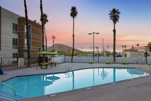 a swimming pool at a hotel with palm trees at SpringHill Suites by Marriott Palm Desert in Palm Desert
