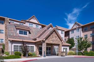 une rangée d'immeubles d'appartements avec une maison dans l'établissement Residence Inn by Marriott Albuquerque Airport, à Albuquerque