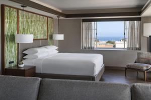 1 dormitorio con cama, sofá y ventana en Monterey Marriott, en Monterey