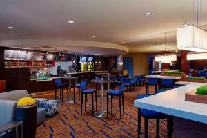 un restaurant avec des tables et des chaises bleues ainsi qu'un bar dans l'établissement Courtyard by Marriott Columbus West/Hilliard, à Columbus