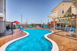 una piscina con sillas azules y un edificio en TownePlace Suites by Marriott Cookeville, en Cookeville