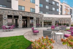 een patio met paarse stoelen en tafels voor een gebouw bij Courtyard by Marriott Cleveland Elyria in Elyria