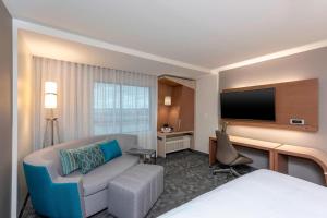 a hotel room with a bed and a tv at Courtyard by Marriott Cleveland Elyria in Elyria