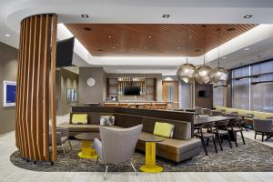 a hotel lobby with tables and chairs and a bar at SpringHill Suites by Marriott Columbus Dublin in Dublin