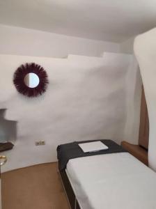 um quarto com uma cama e um espelho na parede em ELECTRAS LITTLE COTTAGE em Andros