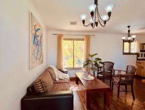 ein Wohnzimmer mit einem Sofa und einem Tisch in der Unterkunft איתן בקתות עץ Eitan Wood Cabins Resort in Sede Eli‘ezer