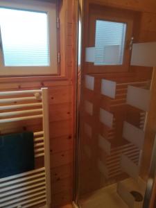 a bathroom with a shower and a tv in a room at Roulot'So Zen in Beslon