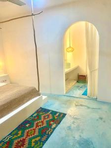 a bedroom with blue floors and a bed and a mirror at Guru Canggu in Canggu