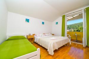 a bedroom with two beds and a large window at Apartment Chiara Martinscica in Martinšćica