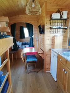 una pequeña cocina con mesa en una cabaña de madera en Roulot'So Zen, en Beslon