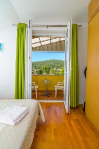 1 dormitorio con 1 cama con cortinas verdes y mesa en Apartment Chiara Martinscica, en Martinšćica