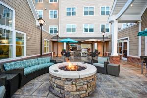 een patio met banken en een vuurplaats voor een gebouw bij Residence Inn by Marriott Springfield Chicopee in Chicopee