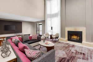 a living room with a couch and a fireplace at Courtyard by Marriott Dallas Lewisville in Lewisville