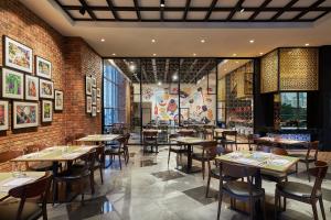 a restaurant with tables and chairs and a brick wall at Four Points by Sheraton Kuala Lumpur, Chinatown in Kuala Lumpur