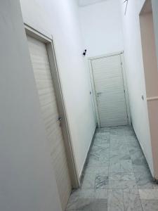ナポリにあるDama HostelBBのタイルフロアの客室内の白いガレージドア2つ