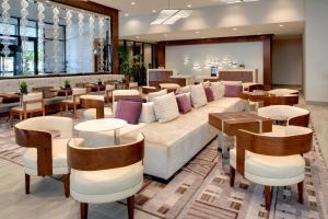 a lobby with a couch and tables and chairs at Marriott East Lansing at University Place in Lansing