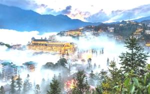 a view of a city with fog in the mountains at THANH XUAN Hotel in Sapa