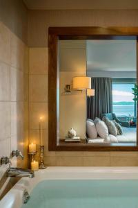 a bathroom with a tub with a mirror and a bedroom at Courtyard Burlington Harbor in Burlington