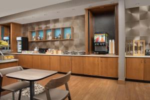 SpringHill Suites by Marriott Huntsville West/Research Park في هانتسفيل: مطبخ مع طاولة وكراسي وكاونتر