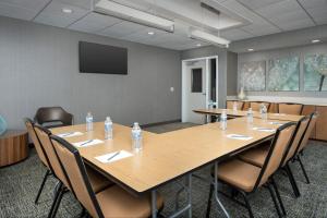 SpringHill Suites by Marriott Huntsville West/Research Park في هانتسفيل: قاعة المؤتمرات مع طاولة وكراسي مع زجاجات المياه