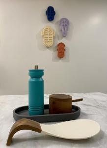 une table avec une bouteille bleue sur une plaque avec une planche de surf dans l'établissement Canarios Apartments Cardal - ll, à Lisbonne