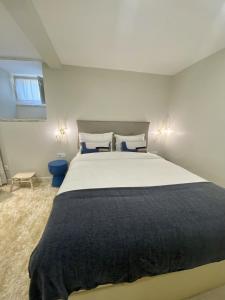 ein Schlafzimmer mit einem großen weißen Bett mit blauen Kissen in der Unterkunft Canarios Apartments Cardal - ll in Lissabon