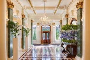 a lobby with a chandelier and flowers on the walls at The Shelbourne, Autograph Collection in Dublin
