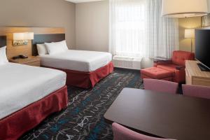 a hotel room with two beds and a couch at TownePlace Suites Midland South/I-20 in Midland