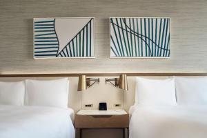 two beds in a hotel room with two pictures on the wall at JW Marriott Hotel Mexico City Polanco in Mexico City