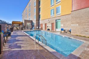 a swimming pool with chairs next to a building at SpringHill Suites by Marriott Chattanooga North/Ooltewah in Ooltewah