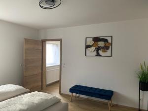 a bedroom with a bed and a blue bench at Schusterbrand Appartements in Absam