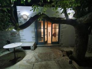 a tree with a bench in front of a door at PYRGOS - Traditional house at Kaloxilos, Naxos in Khalkíon +45 photos