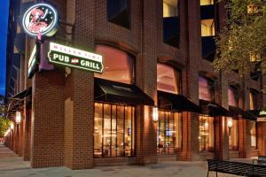 ein Backsteingebäude mit einem Schild für einen Pub und einen Grill in der Unterkunft The Lincoln Marriott Cornhusker Hotel in Lincoln