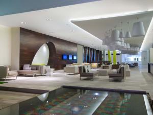 a lobby with chairs and a pool in the middle at Krystal Grand Puerto Vallarta - All Inclusive in Puerto Vallarta