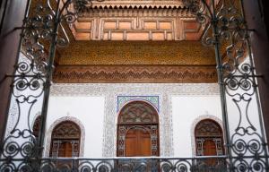 an entrance to a building with three wooden doors at Dar El Arfaoui in Fez