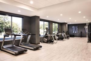 un gimnasio con cintas de correr y elípticas en una habitación con ventanas en AC Hotel by Marriott Nashville Brentwood, en Brentwood