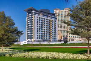 Residence Inn by Marriott Al Jaddaf في دبي: مبنى كبير أمامه حديقة