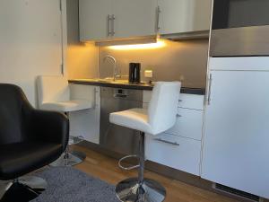 a small kitchen with two chairs and a sink at Oslo center 4 in Oslo