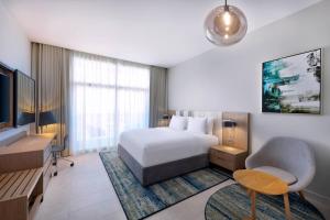 Residence Inn by Marriott Al Jaddaf في دبي: غرفة فندق بسرير وتلفزيون