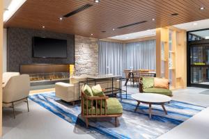 a lobby with furniture and a tv on a wall at Fairfield by Marriott Inn & Suites Medford in Medford