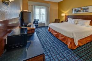 ein Hotelzimmer mit einem Bett und einem Flachbild-TV in der Unterkunft Fairfield by Marriott Russellville in Russellville