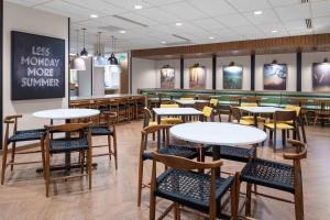 a restaurant with tables and chairs in a cafeteria at Fairfield by Marriott Inn & Suites Medford in Medford