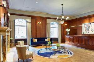 uma sala de estar com um sofá azul e uma mesa em London Marriott Hotel County Hall em Londres