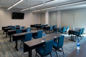 a conference room with tables and blue chairs at Four Points by Sheraton Kansas City Olathe in Olathe