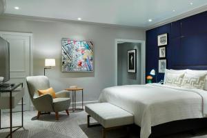 a bedroom with a king sized bed and a chair at London Marriott Hotel County Hall in London