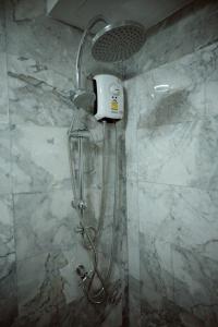 a shower with a shower head in a bathroom at 777 Beach Condo Phuket in Mai Khao Beach